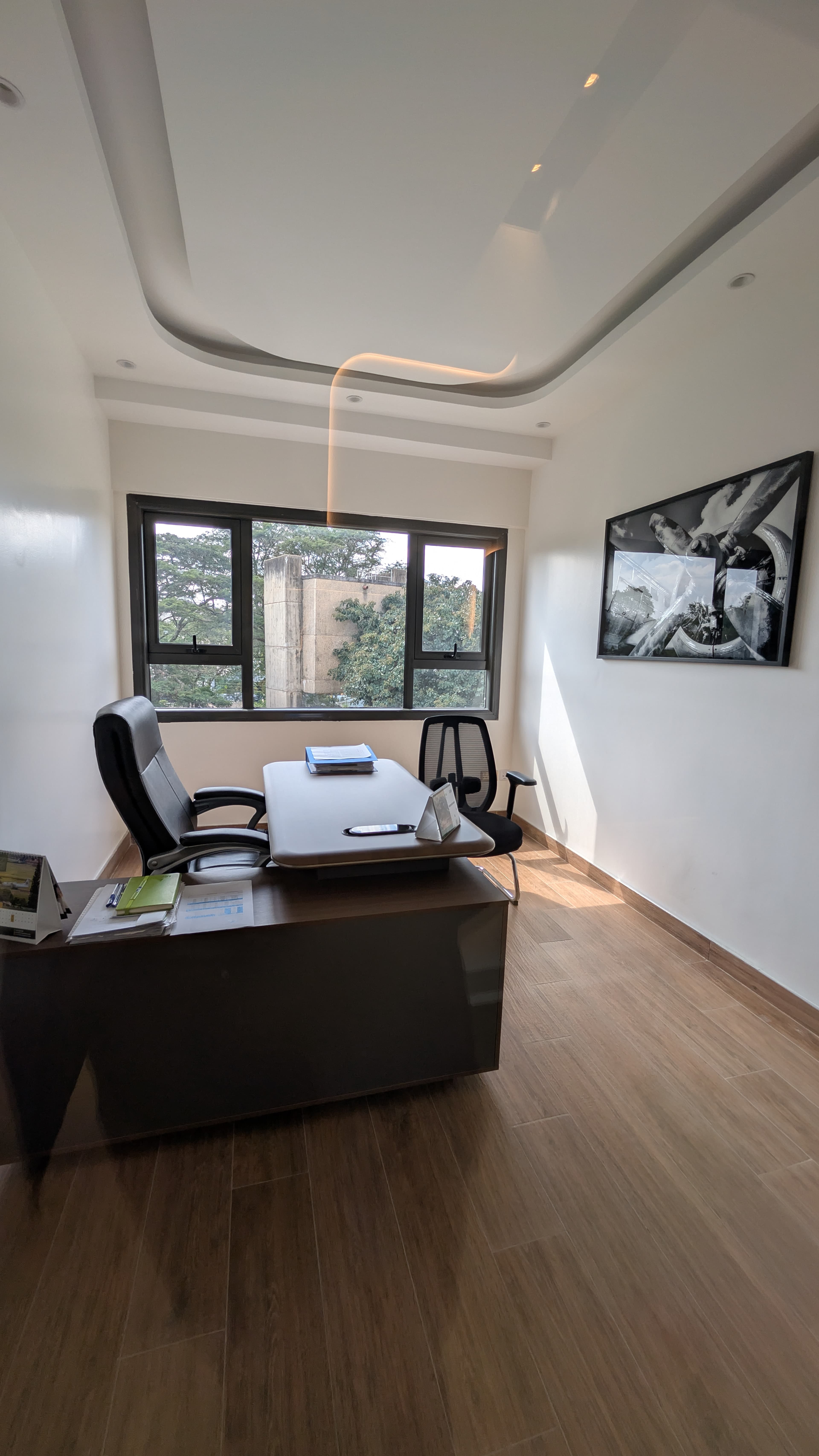 Open plan workspace — warm white walls, uniform track lighting